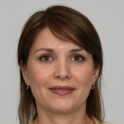 Joyful white adult female with medium  brown hair and grey eyes