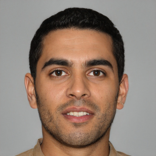 Joyful latino young-adult male with short  brown hair and brown eyes