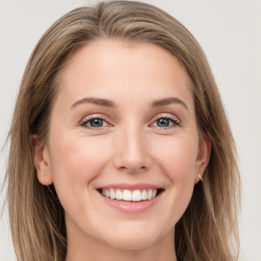 Joyful white young-adult female with long  brown hair and grey eyes