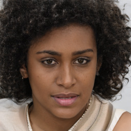 Joyful black young-adult female with long  brown hair and brown eyes