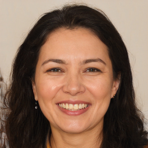 Joyful white adult female with long  brown hair and brown eyes