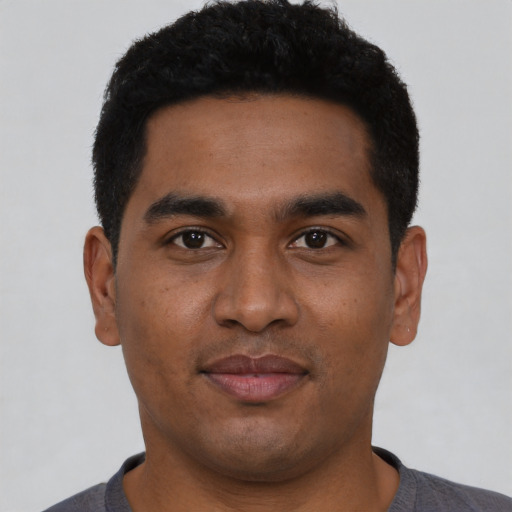 Joyful latino young-adult male with short  black hair and brown eyes