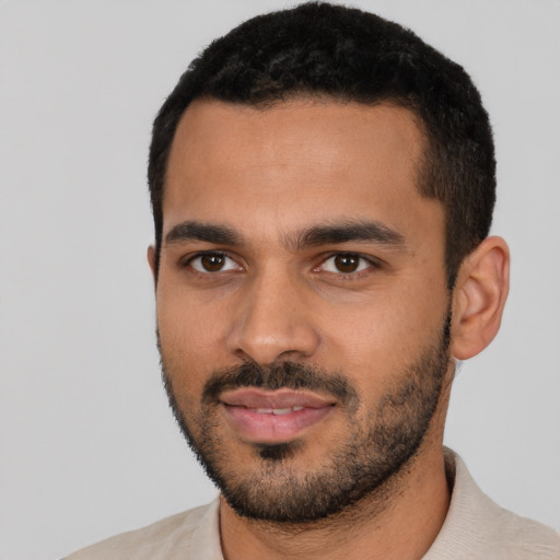 Joyful latino young-adult male with short  black hair and brown eyes