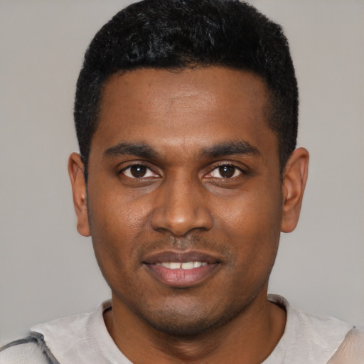 Joyful black young-adult male with short  black hair and brown eyes