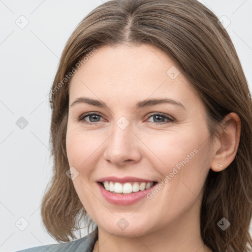 Joyful white young-adult female with long  brown hair and grey eyes