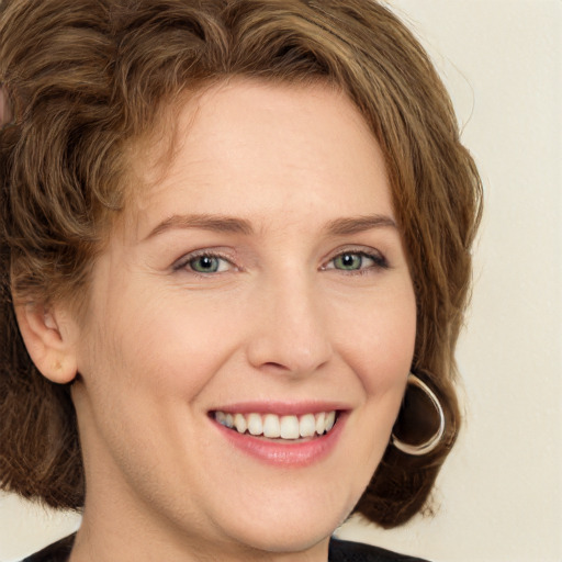 Joyful white young-adult female with medium  brown hair and green eyes