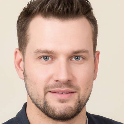 Joyful white young-adult male with short  brown hair and grey eyes