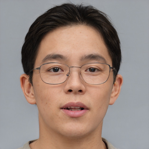 Joyful asian adult male with short  brown hair and brown eyes