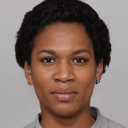 Joyful black young-adult female with short  black hair and brown eyes