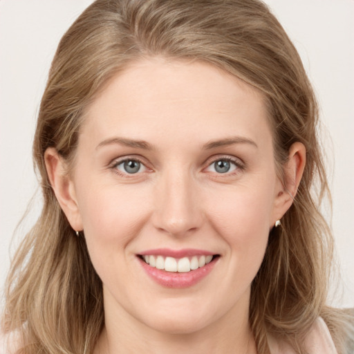 Joyful white young-adult female with long  brown hair and blue eyes