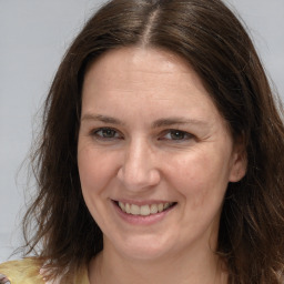 Joyful white adult female with long  brown hair and brown eyes