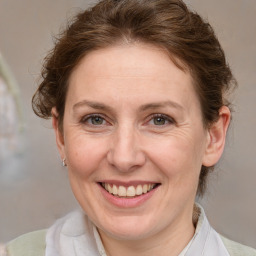 Joyful white adult female with medium  brown hair and blue eyes