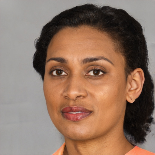 Joyful black young-adult female with short  black hair and brown eyes