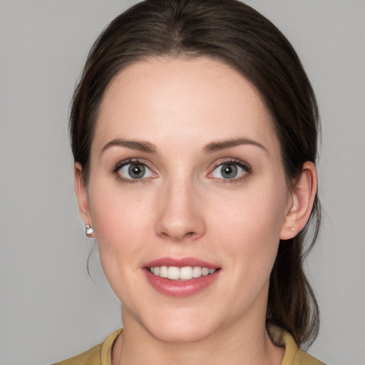 Joyful white young-adult female with medium  brown hair and grey eyes