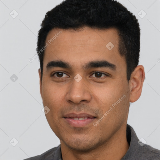 Joyful latino young-adult male with short  black hair and brown eyes