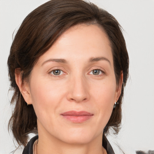 Joyful white adult female with medium  brown hair and grey eyes