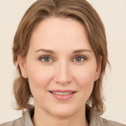 Joyful white young-adult female with medium  brown hair and grey eyes