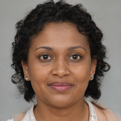 Joyful black adult female with medium  brown hair and brown eyes