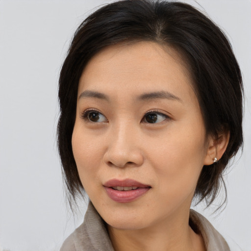 Joyful asian young-adult female with medium  brown hair and brown eyes