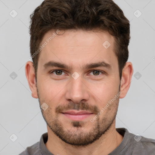 Joyful white young-adult male with short  brown hair and grey eyes