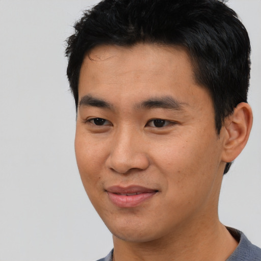 Joyful asian young-adult male with short  black hair and brown eyes