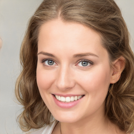 Joyful white young-adult female with long  brown hair and green eyes