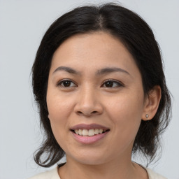 Joyful asian young-adult female with medium  brown hair and brown eyes