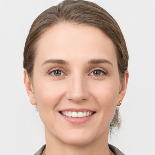 Joyful white young-adult female with medium  brown hair and grey eyes