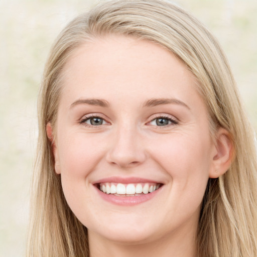 Joyful white young-adult female with long  brown hair and blue eyes