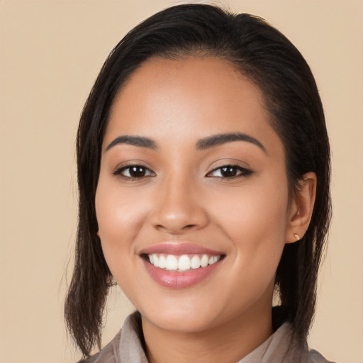 Joyful latino young-adult female with long  brown hair and brown eyes