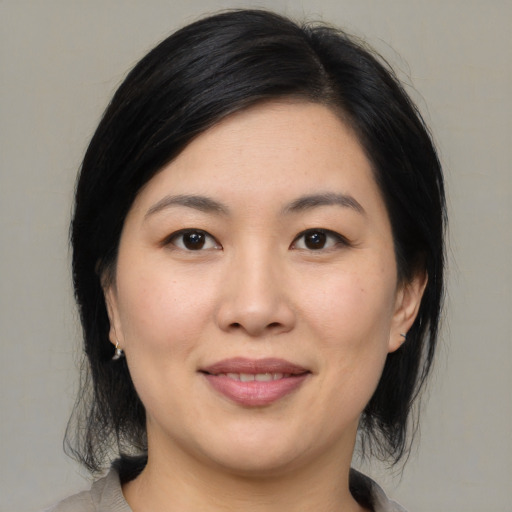Joyful asian young-adult female with medium  black hair and brown eyes