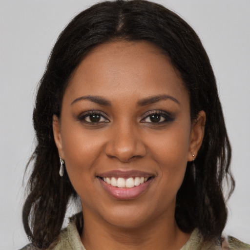 Joyful black young-adult female with long  brown hair and brown eyes