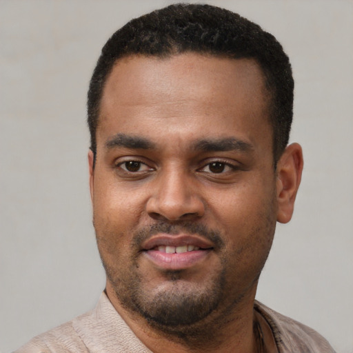 Joyful black young-adult male with short  black hair and brown eyes