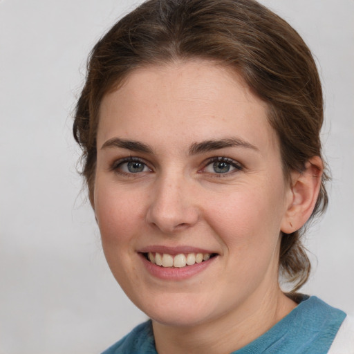 Joyful white young-adult female with medium  brown hair and blue eyes