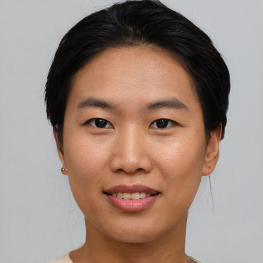 Joyful asian young-adult female with short  brown hair and brown eyes