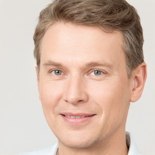 Joyful white adult male with short  brown hair and grey eyes