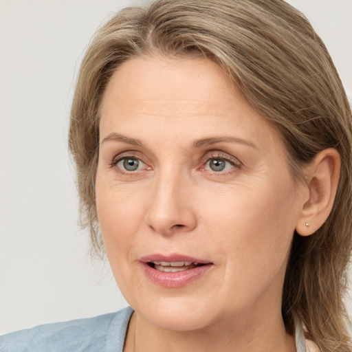 Joyful white adult female with medium  brown hair and blue eyes