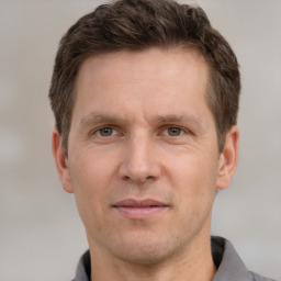 Joyful white adult male with short  brown hair and grey eyes