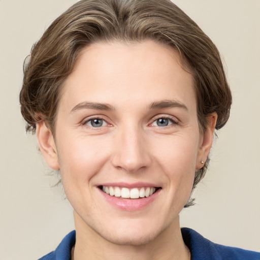 Joyful white young-adult female with medium  brown hair and grey eyes