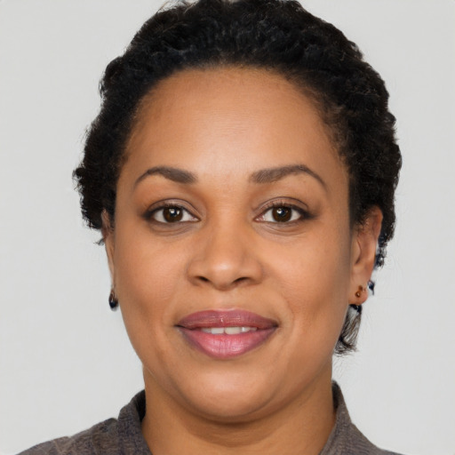 Joyful black adult female with short  black hair and brown eyes