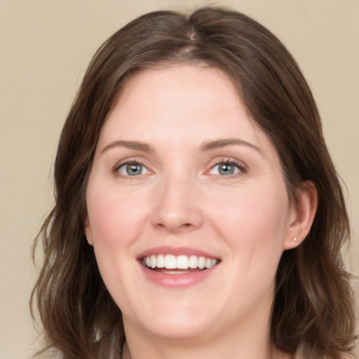 Joyful white young-adult female with medium  brown hair and green eyes