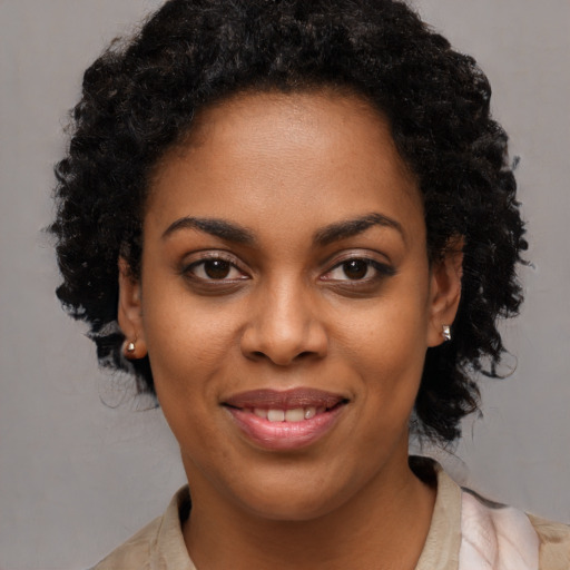 Joyful black young-adult female with long  brown hair and brown eyes