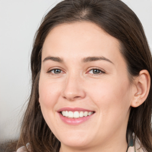 Joyful white young-adult female with medium  brown hair and grey eyes