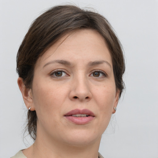 Joyful white young-adult female with medium  brown hair and grey eyes