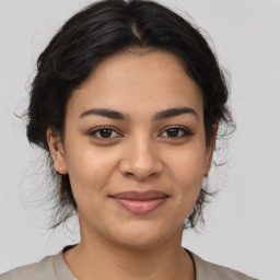 Joyful latino young-adult female with medium  brown hair and brown eyes