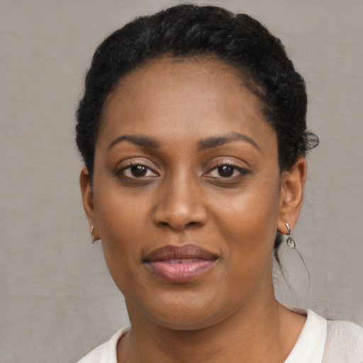 Joyful black adult female with short  black hair and brown eyes
