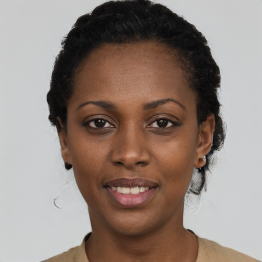 Joyful black young-adult female with short  black hair and brown eyes