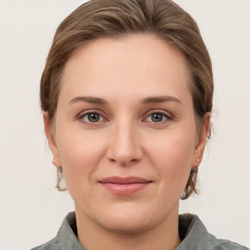 Joyful white young-adult female with medium  brown hair and grey eyes