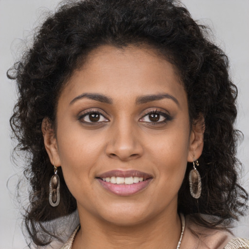 Joyful black young-adult female with long  brown hair and brown eyes