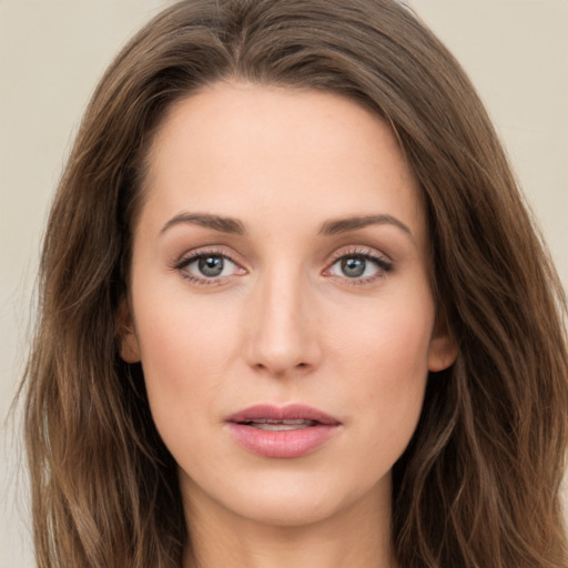 Joyful white young-adult female with long  brown hair and green eyes